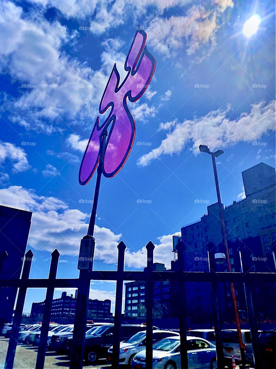 This is the art object that cast the shadow incl. the semi opaque imprint of the transparent magenta shape on top of the pole attachment to this city fence in LIC, Queens. It reminds of a piece to a jigsaw puzzle. 2022. Hypnotic Productions