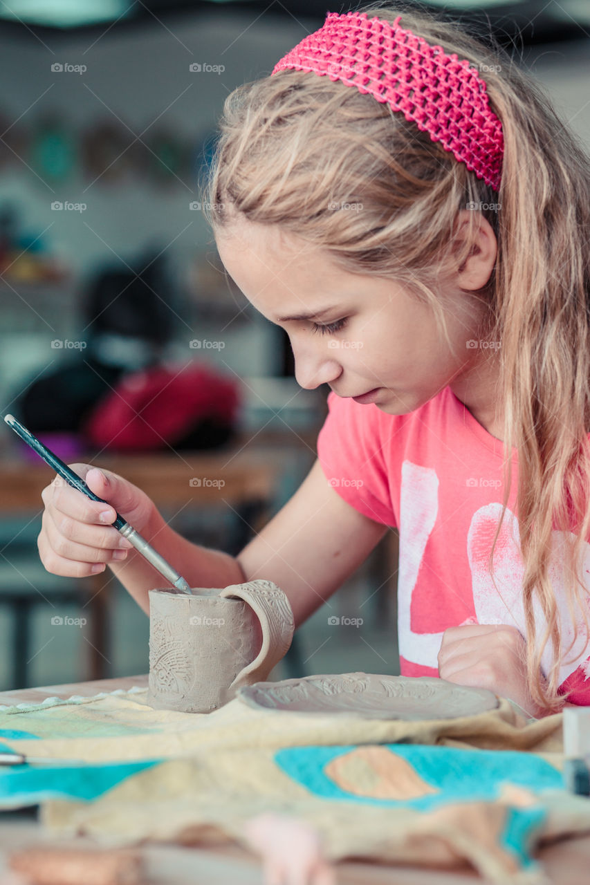 Girl making her first pottery in ceramic workshop