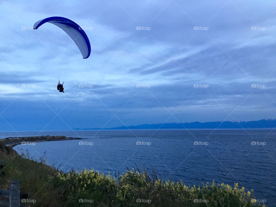 Paraglider flying over sea