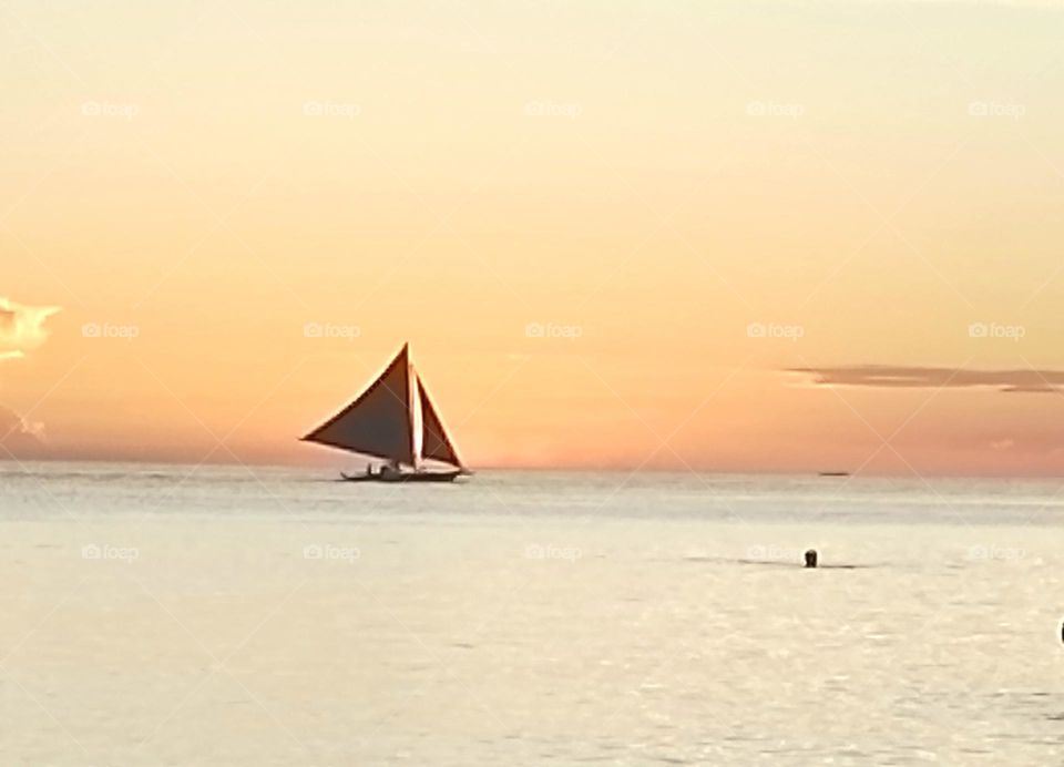 Sailing thru the horizon. Enjoying the sunset in calm waters