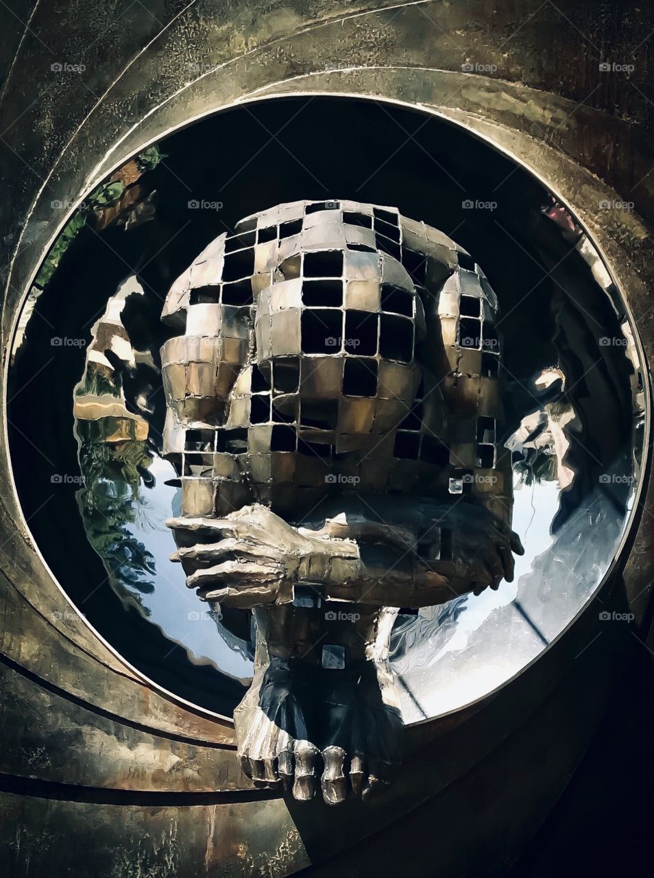 Statue of a man in a fetal position 