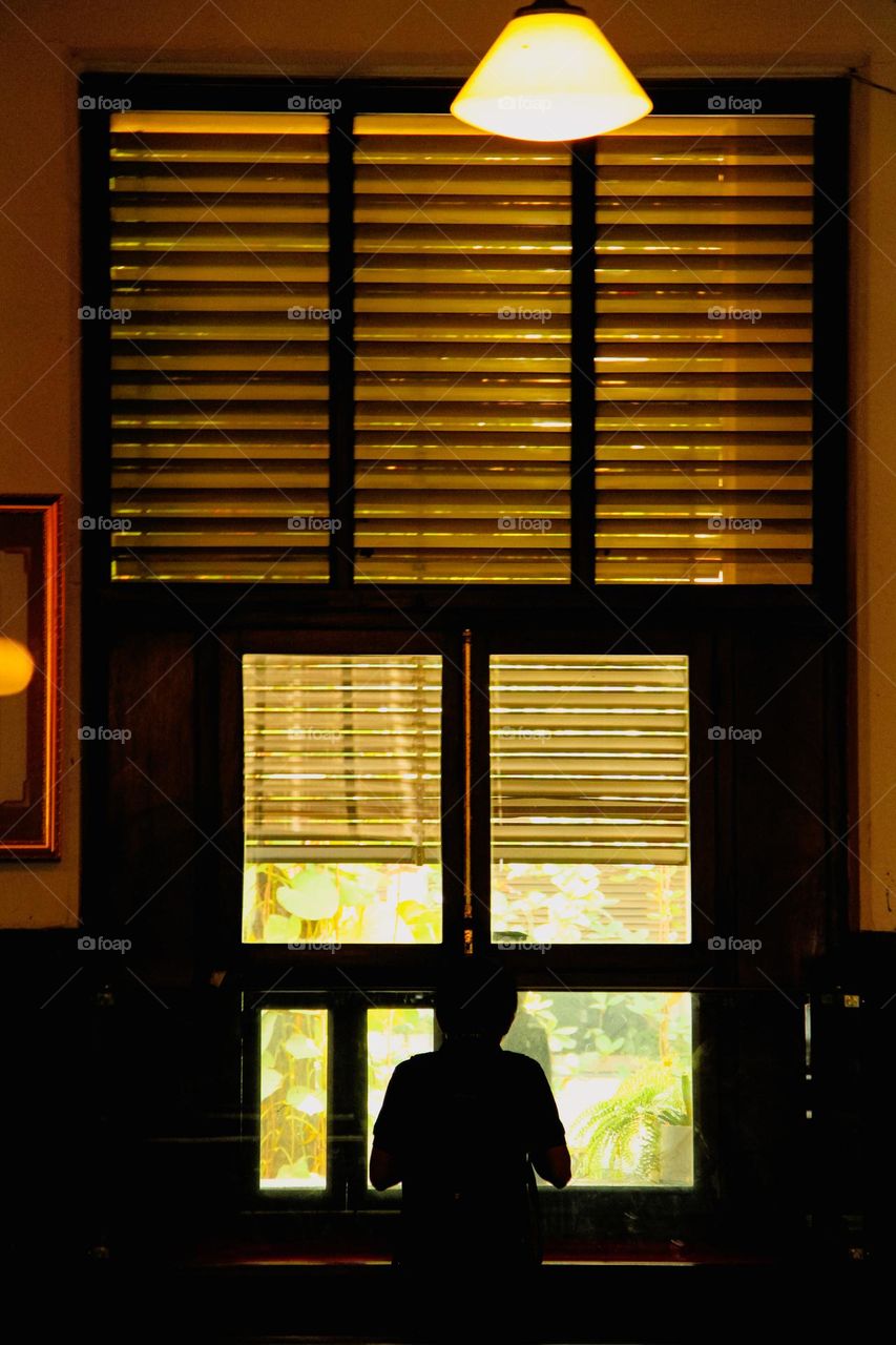 portrait of a person standing in front of a window in the afternoon.