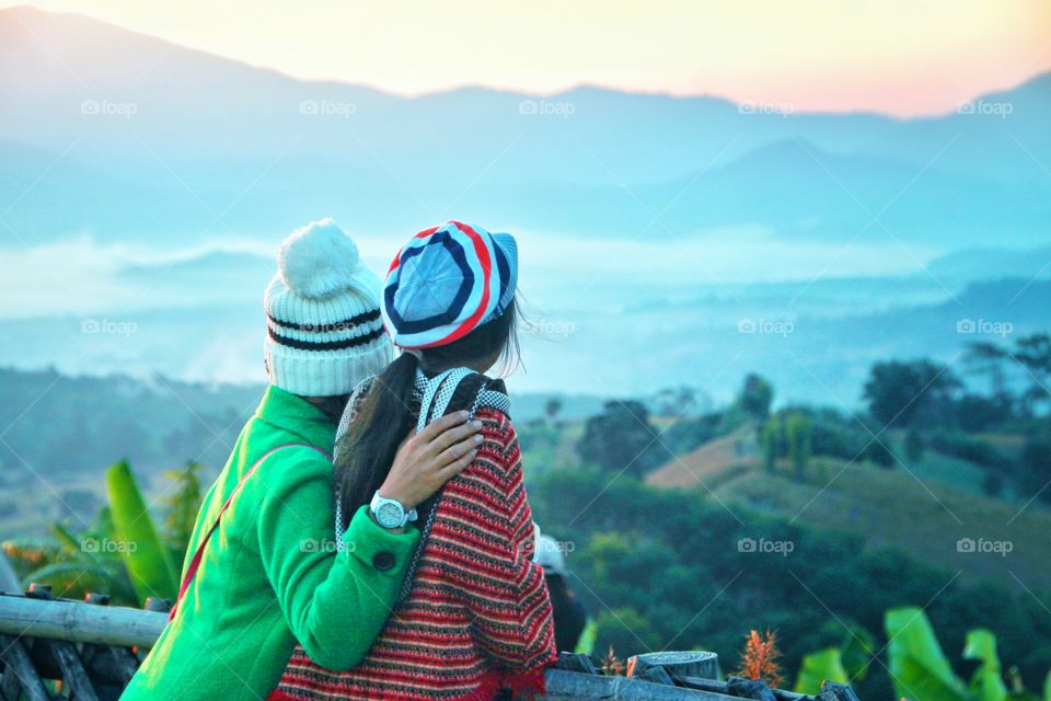 2 tourists are standing in the morning viewpoint  To experience the cold weather and watch the morning mist  At Yun Lai Viewpoint, Pai District, Mae Hong Son Province, Thailand. This is one of the most popular tourist attractions.