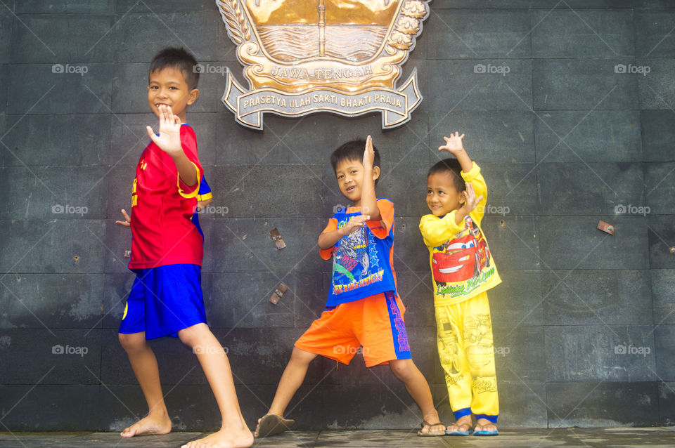 Asian boy posing in front of wall