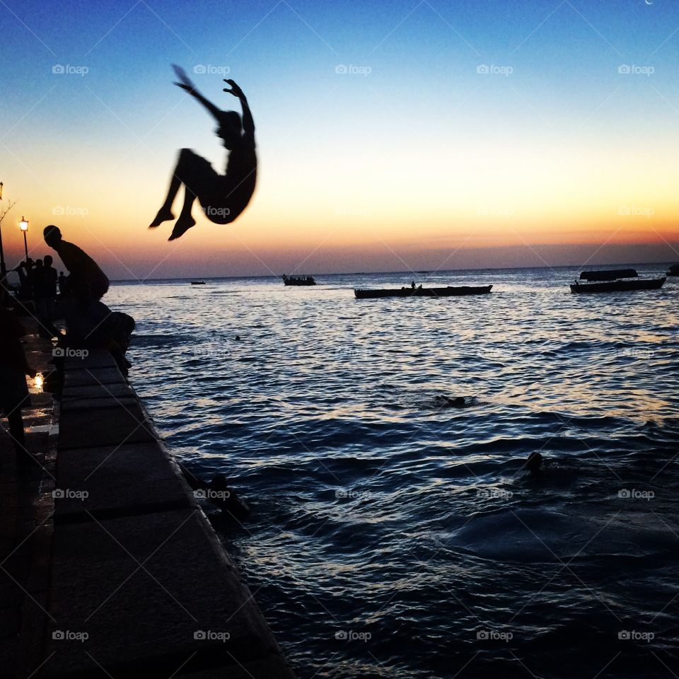 Boy flings himself into the ocean