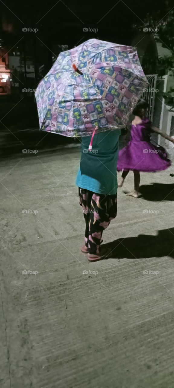 A girl standing taking with umbrella on her head, she not to be safe from rain 🌧️☔, in this season's first rain.