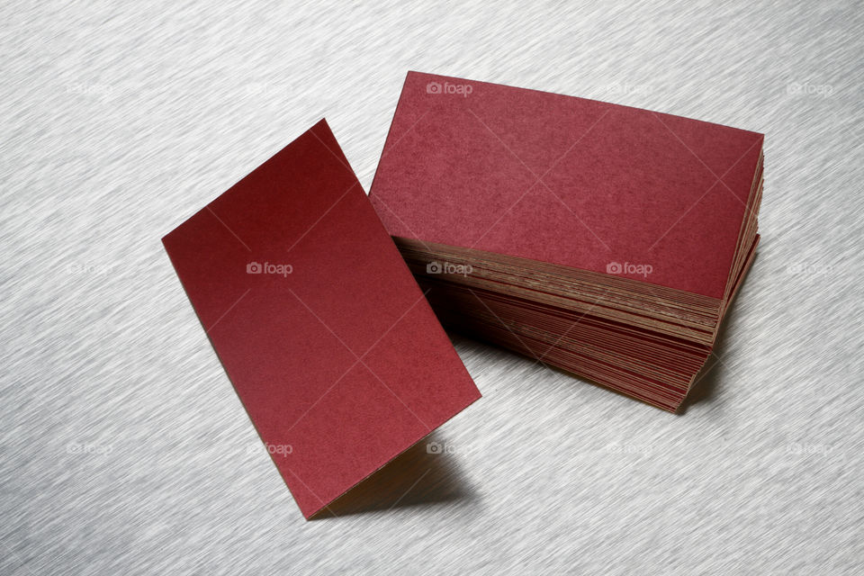 Maroon colored business cards on brushed steel background