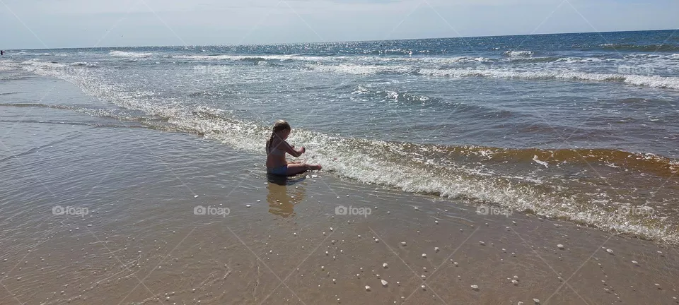 Exploring the ocean. Girl relaxing and playing by the beach.