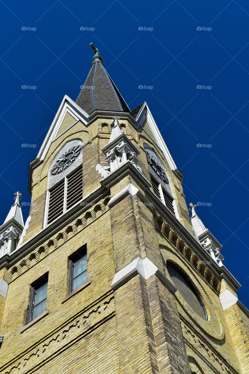 Cream city brick church spire against a blue sky