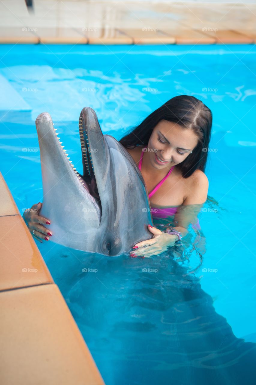 Woman and dolphin in swimming pool