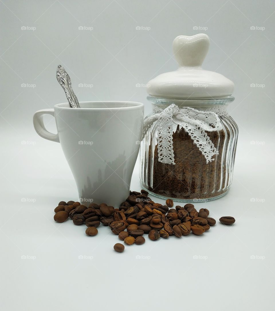 jar filled with coffee and roasted coffee beans on white background, waking up from mugs