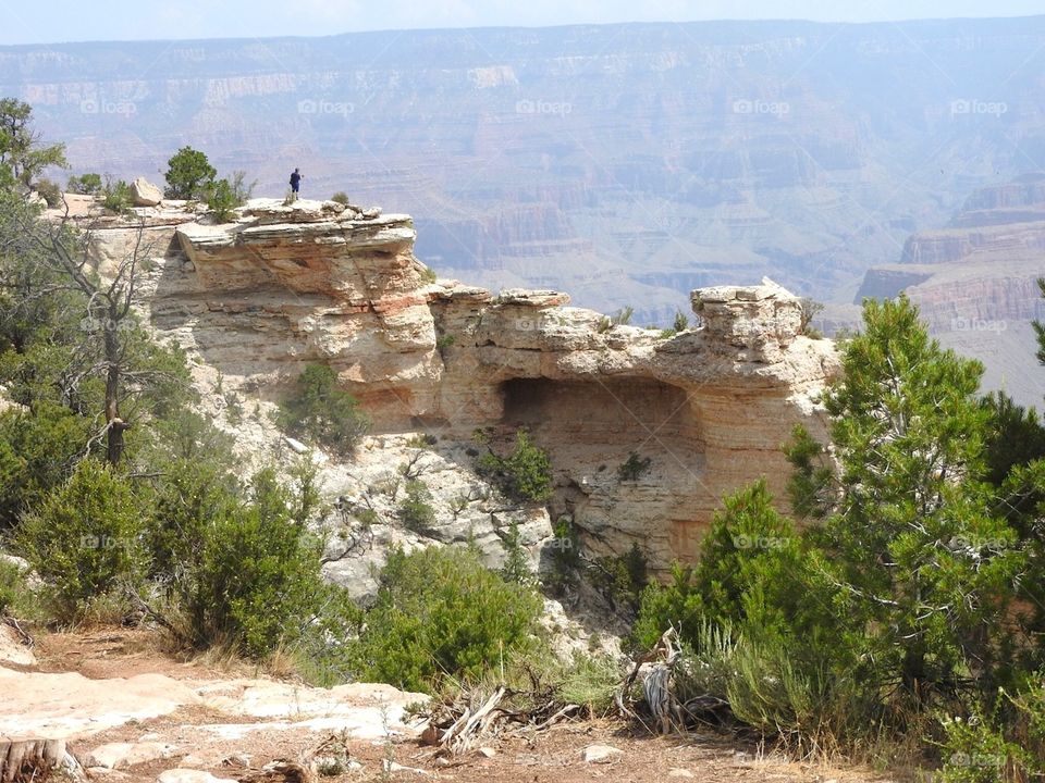 Distant view of a person standing on rocky mountain