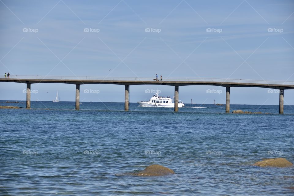 A bridge over the sea and some people walking over