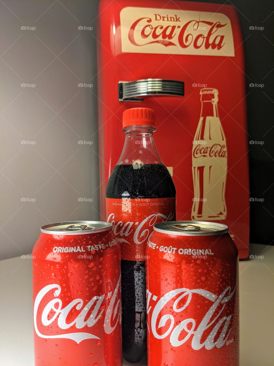 Coke cans and bottles with vintage mini fridge
