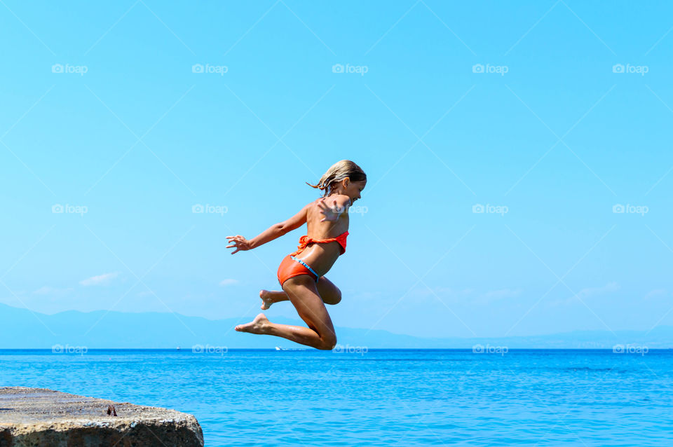 girl is jumping into the sea