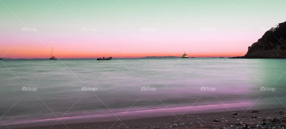 Violet sea under a summer sunset, view from the seashore