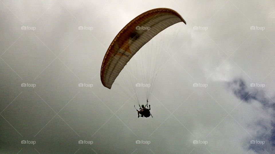 pessoa em um paraquedas no céu nublado