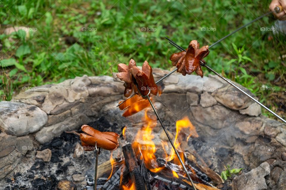 cooking the sausages and meat over the fire