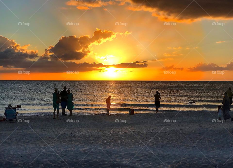 People gathered on the beach to watch a spectacular sunset.