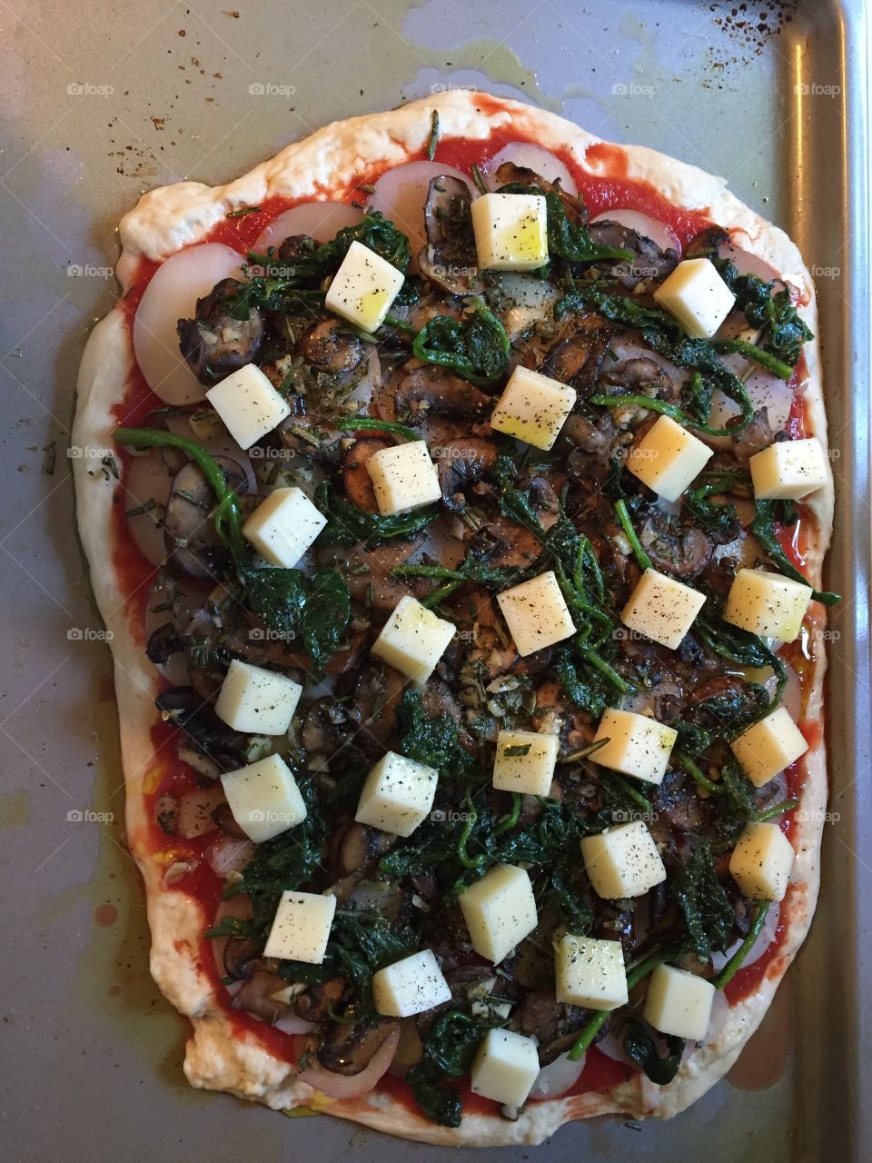 Fresh ingredients on a non-traditional homemade pizza....before it goes in the oven.  Delicious sauce, potatoes, mushrooms, and cubes of cheese on top with a little salt and pepper.  Yum!