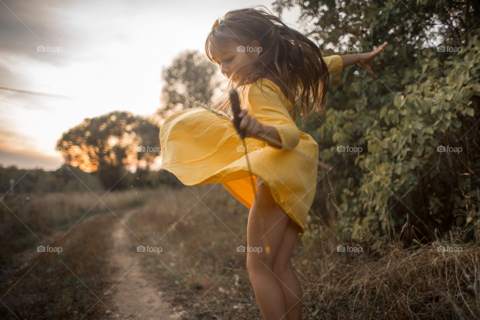 Little girl in yellow dress outdoor portrait at sunset 