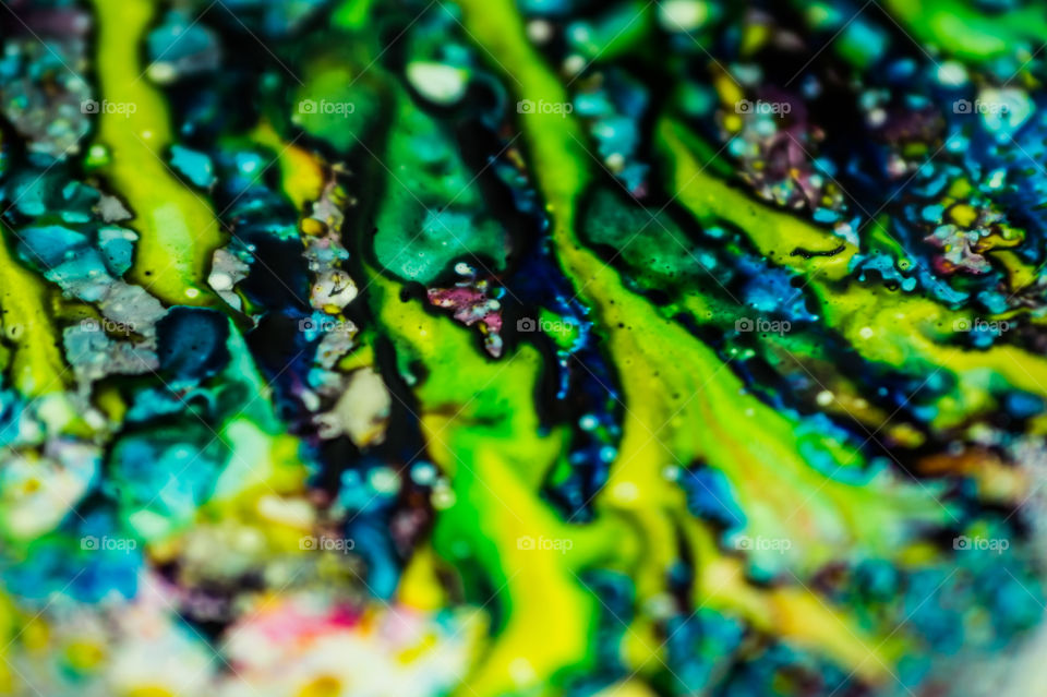 The ink to refill the printer cartridge was spilled onto the white washbasin and the paints blended into abstract drips and patterns.