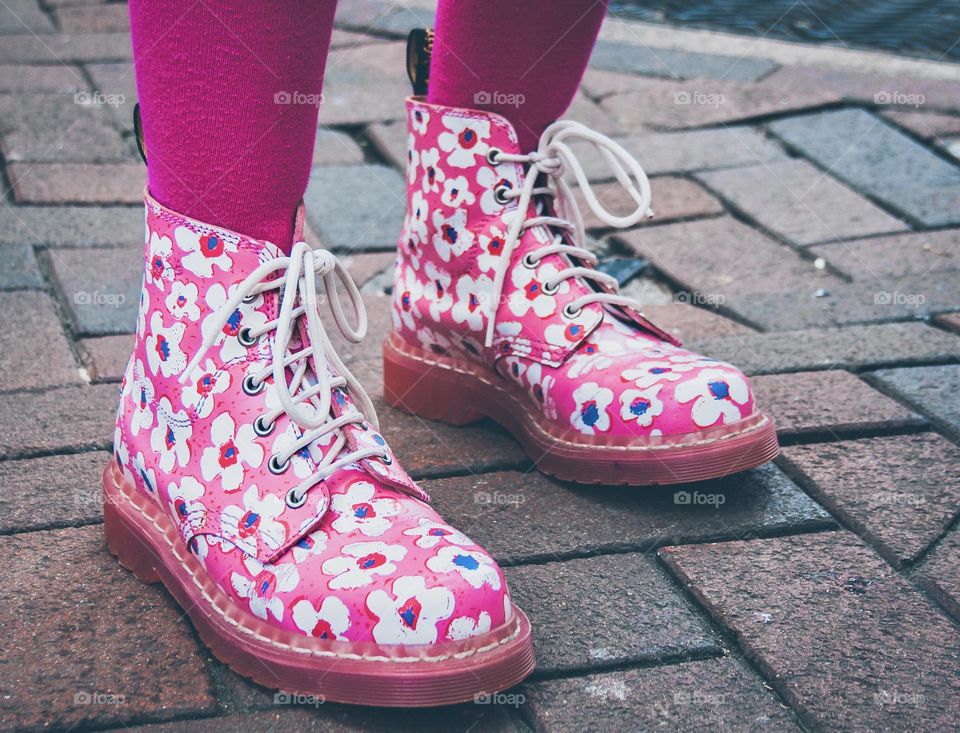 Pink floral DMs with shocking pink tights, against a cobbled street background 