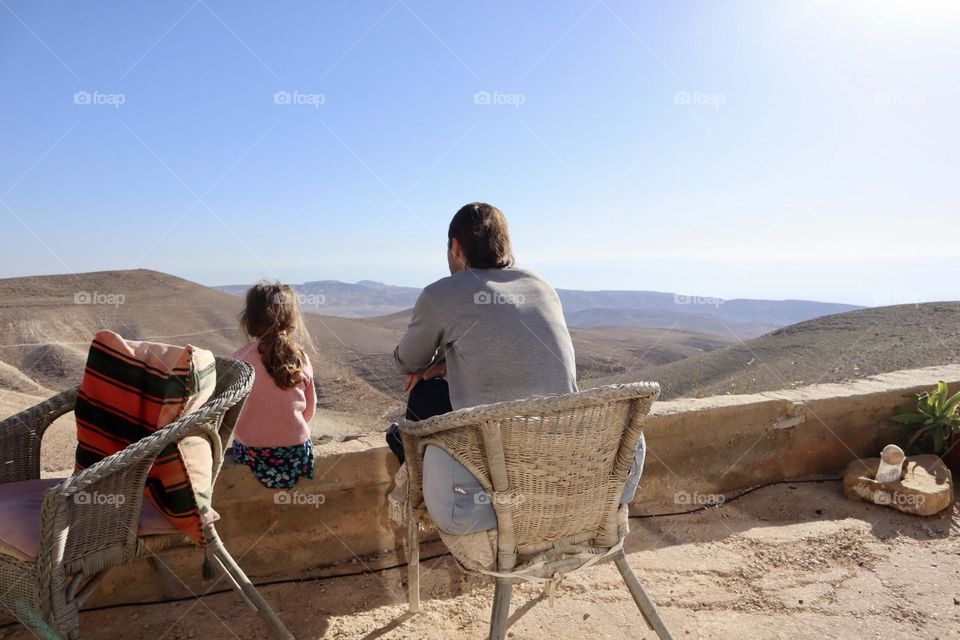 Father and daughter enjoy the quiet of the desert together 