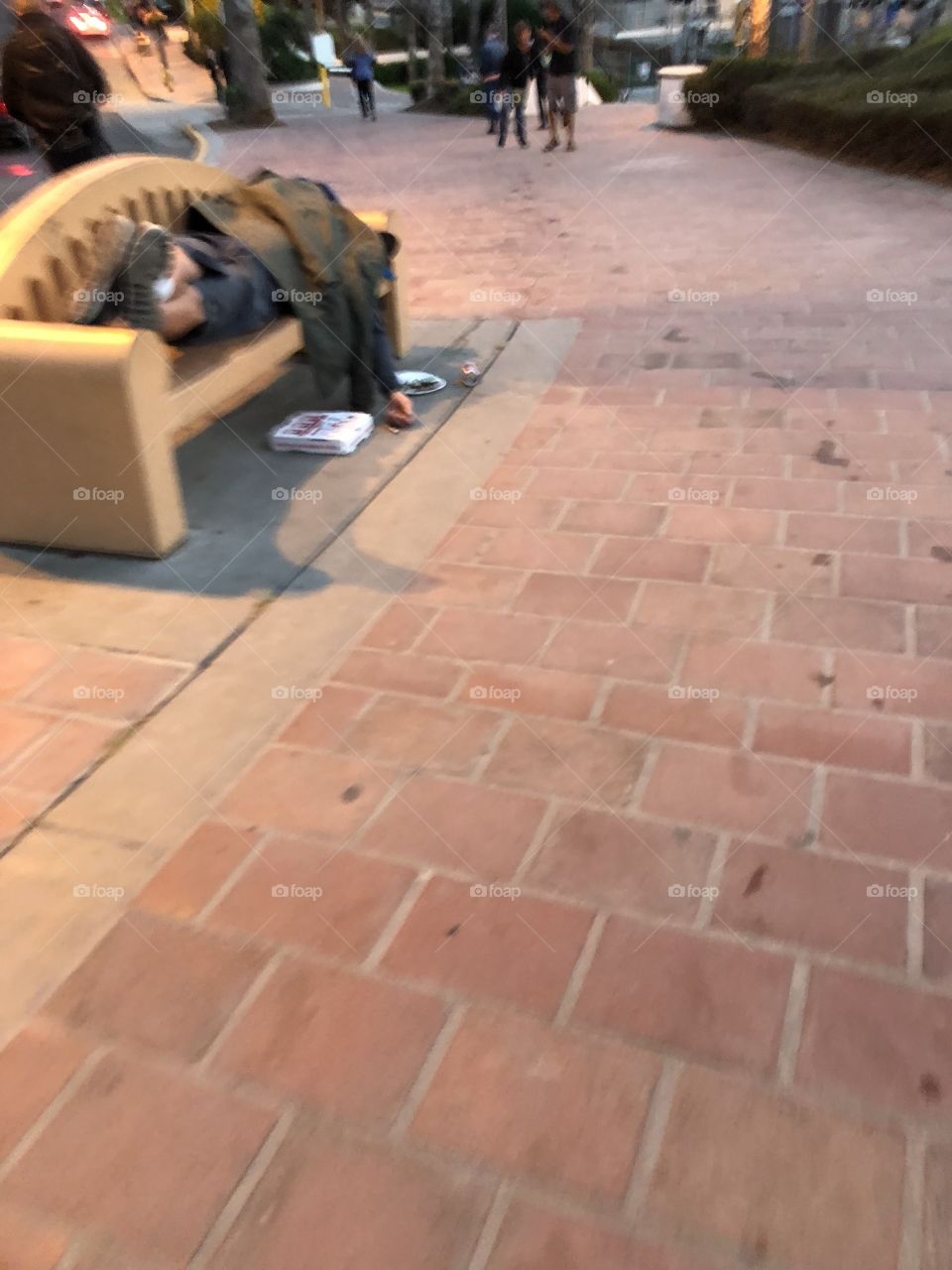 Homeless man sleeping on a bench