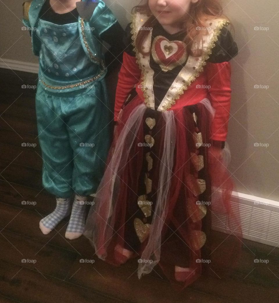 These 2 cute young girls, going out trick or treating on Halloween, dressed up in their funky, colorful, shiny, teal Genie and red, black and white Queen of hearts costumes, and wouldn’t get out of them costumes for a week, they loved them so much