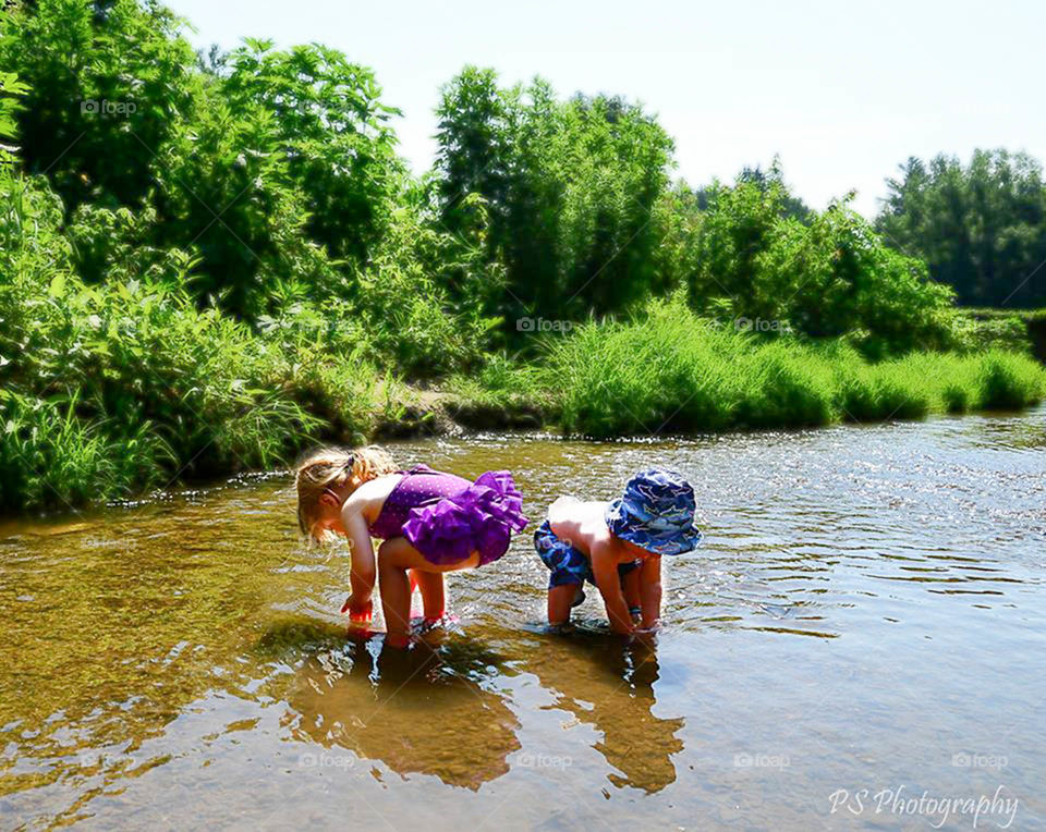 Toddlers wading. Small toddlars wading in the shallow creek