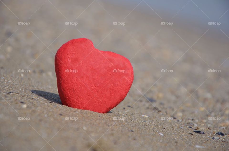 stone red heart on the sand