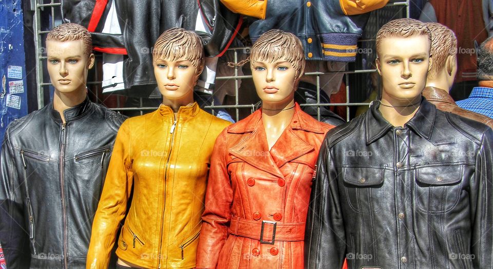 Leather clad dummies. A row of mannequins wearing colourful leather jackets in Camden Market, London.