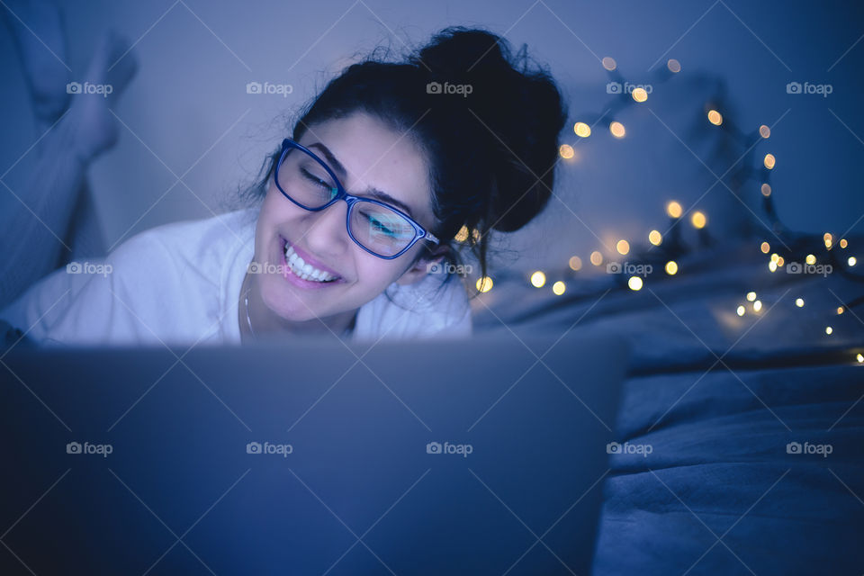 A lady laughing and using the laptop 