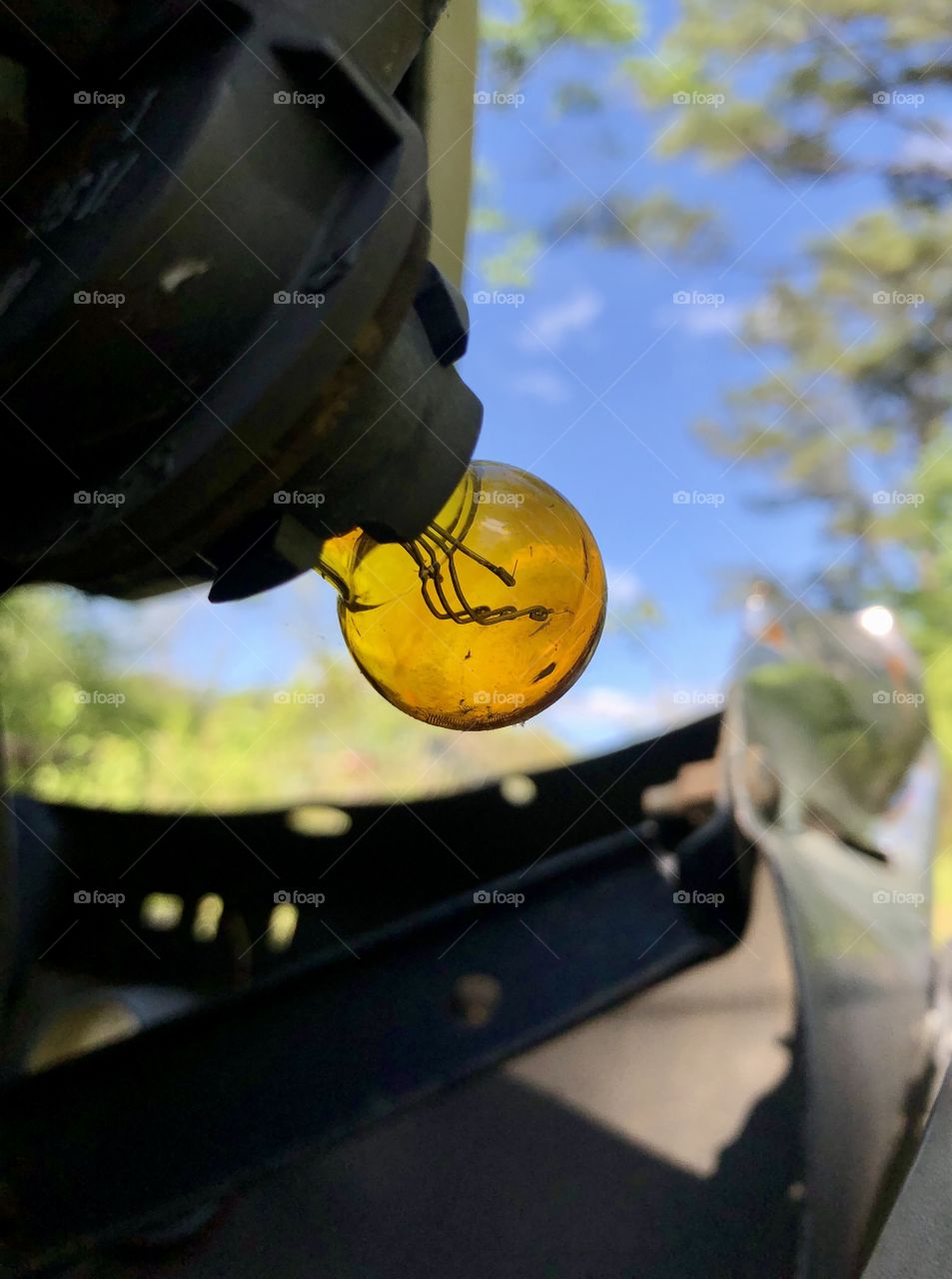 Wrecked truck with exposed automotive light bulb against blue sky 