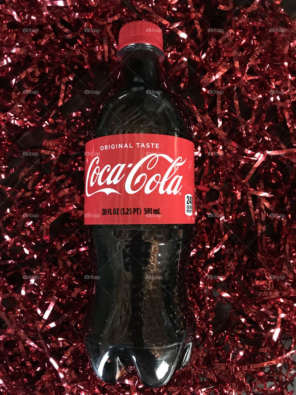 Coca Cola bottle with red shiny tinsel. 