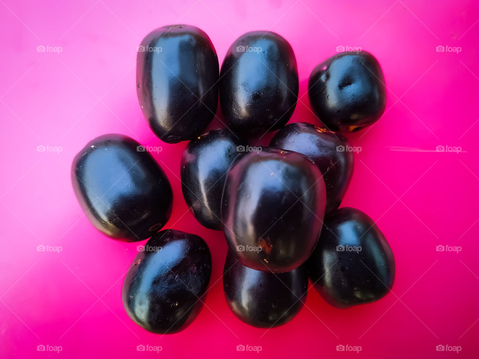 Jambolan plum or java plum on pink background