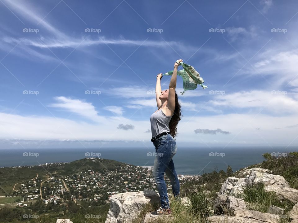 young woman at the top of a hill, with a beautiful sky and the sea behind her @adrianaelizabeth7779