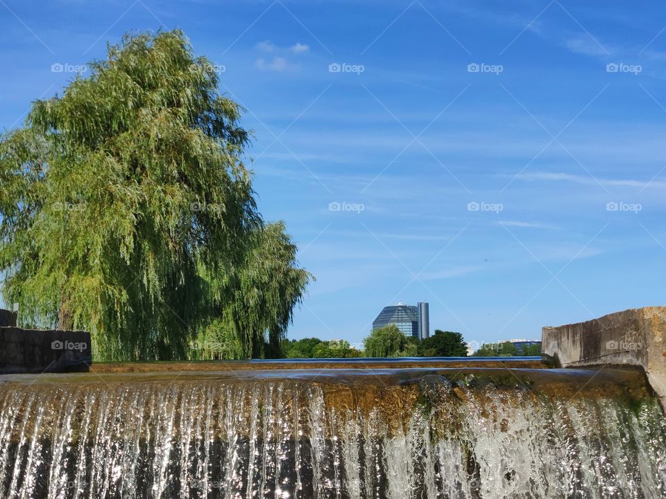Beautiful waterfall on the background of buildings and trees