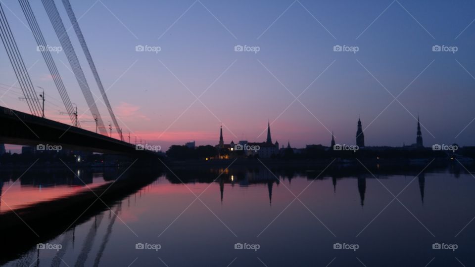 A beautiful sunset over city panorama with river and bridge in Riga, Latvia