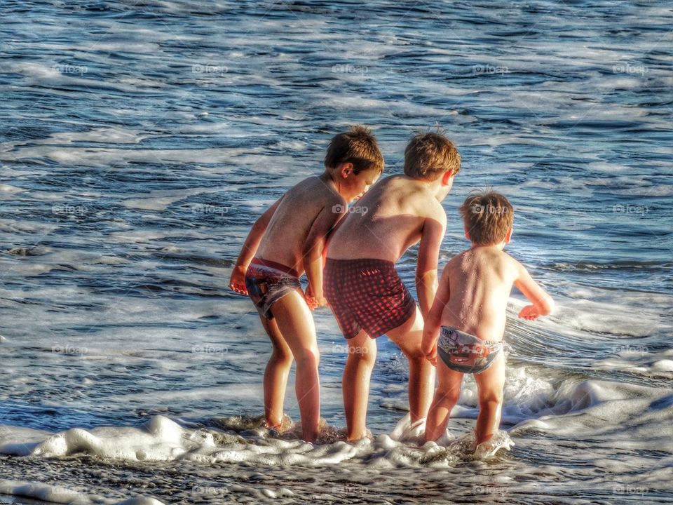 Three Young Brothers Holding Hands At The Seashore. Brothers Holding Hands

