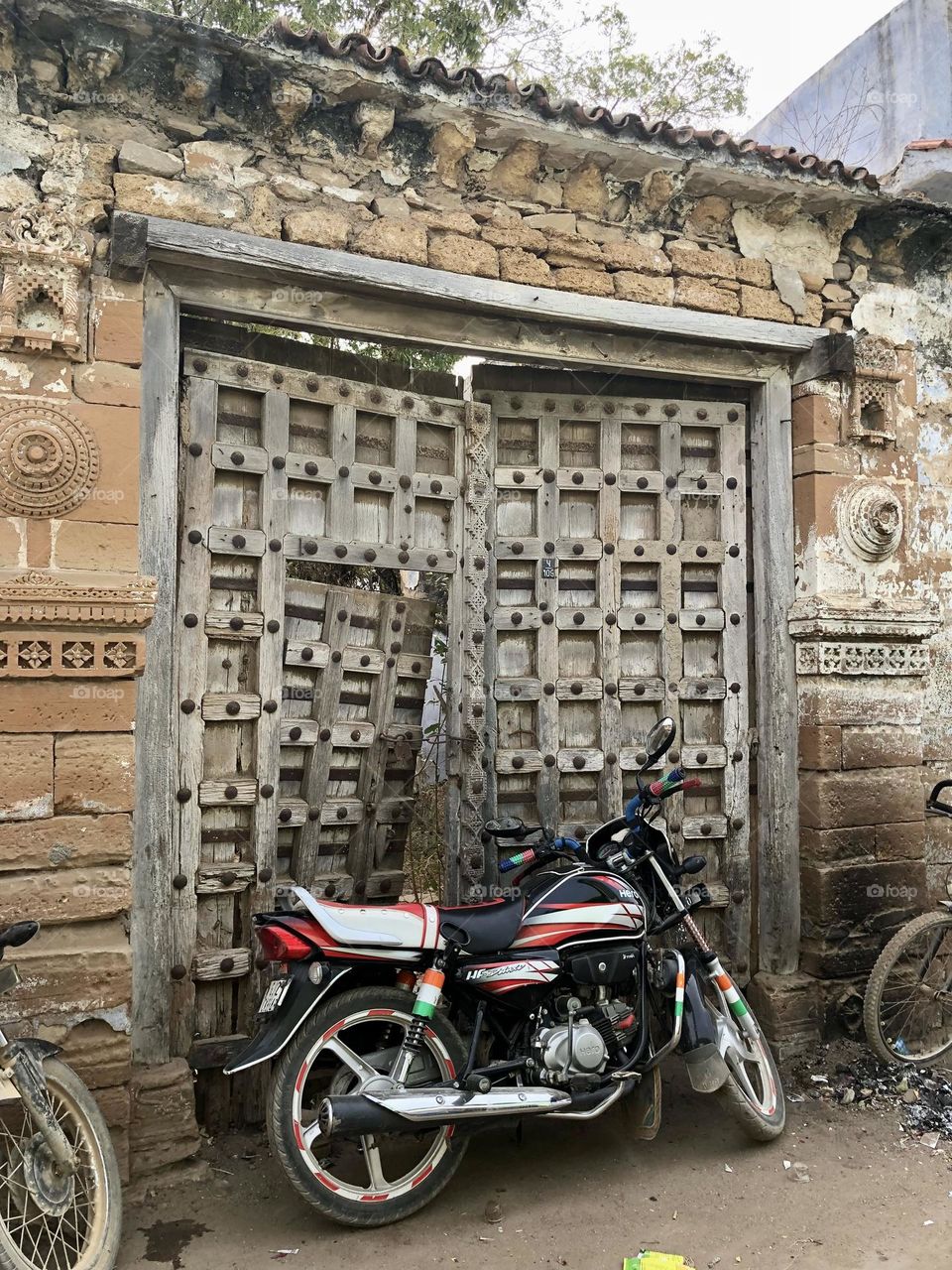 Motorcycle Stationed In Front Of A Carved Door