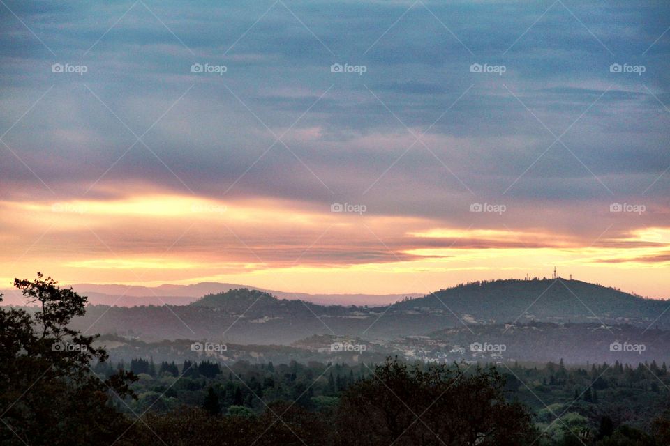 watching the sunrise over the mountains through a cloudy background. mountains, clouds