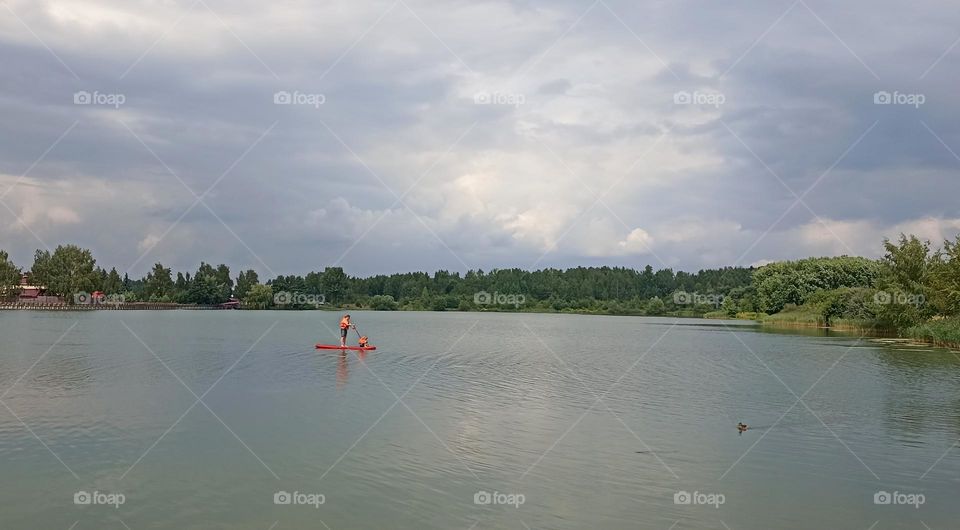 family father and son riding on a boat board on a lake summer time