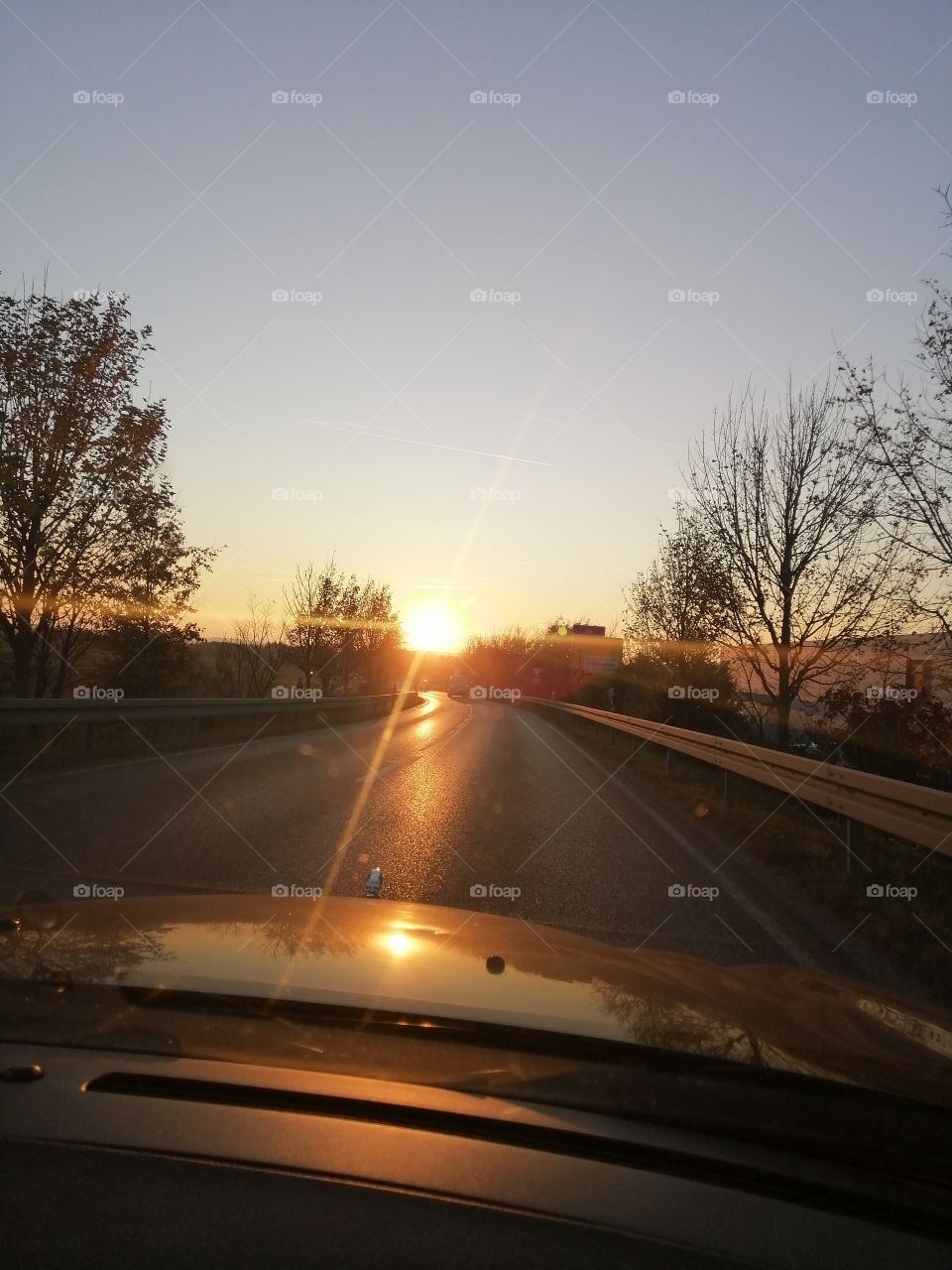 Fahrt mit dem Auto in den roten Sonnenuntergang