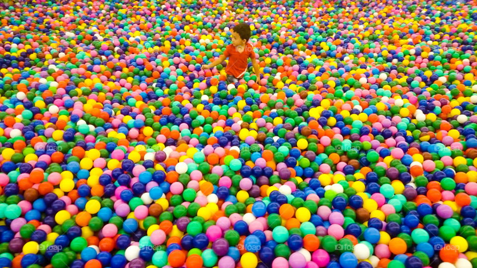 Child sitting in multicolored balls