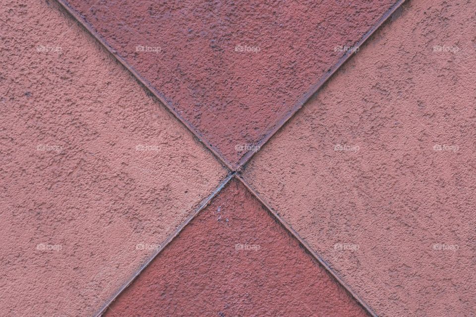 A closeup abstract of a reddish exterior wall of a building.