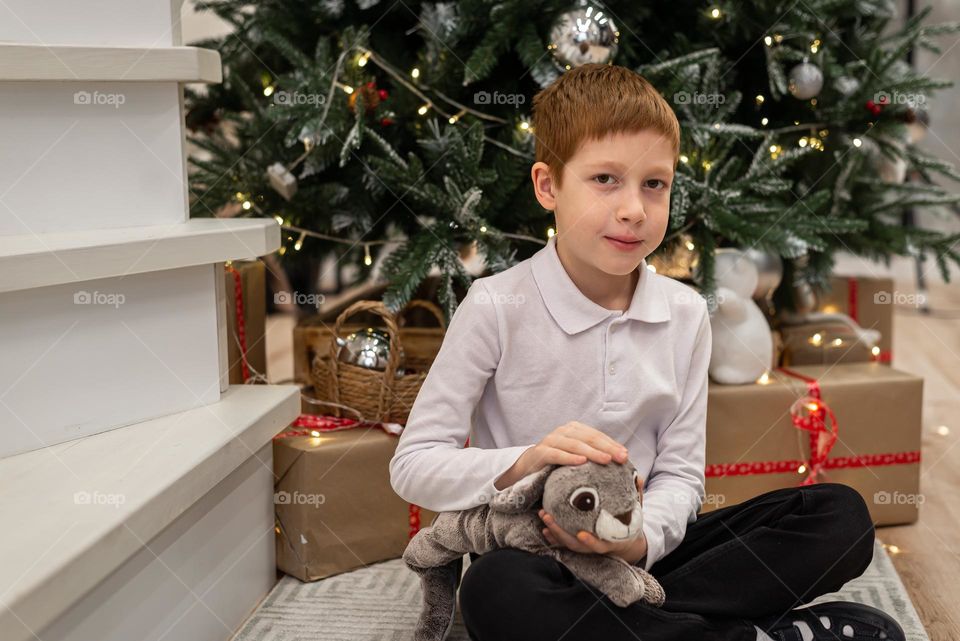 Red haired boy with toy rabbit 