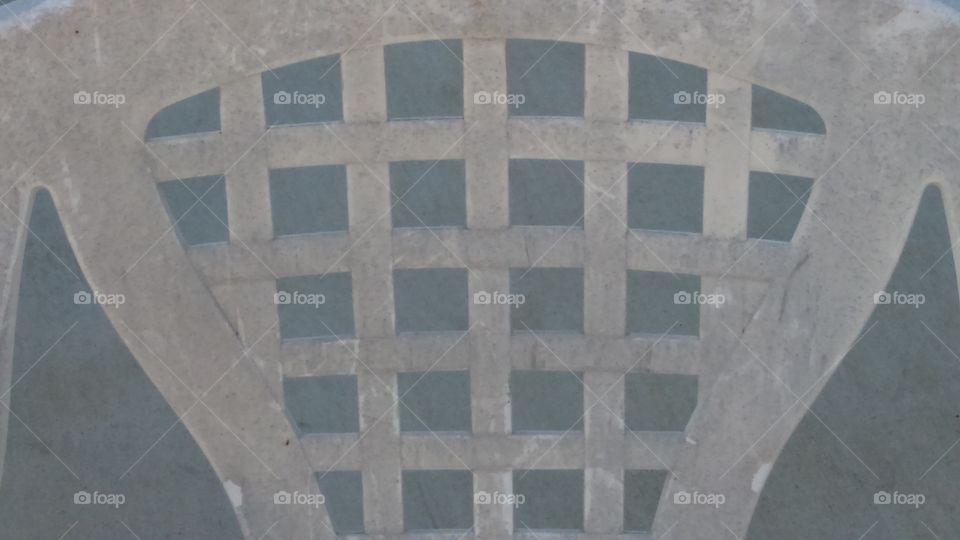 Symmetrical lattice patterned patio chair back.