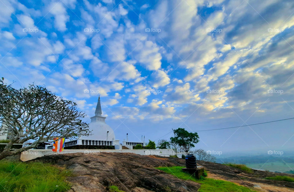 Morning feel of a Buddhist temple with a pagoda on a top of a hill with scenic views in Sri Lanka.